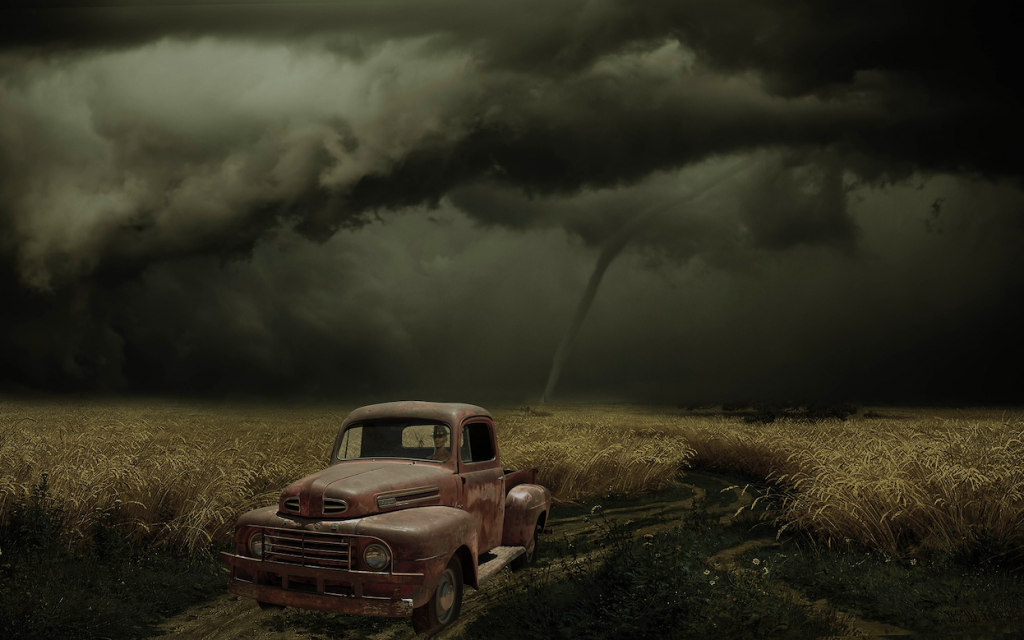 An old car in the middle of a corn field, a very dark sky above