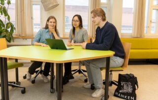 Three students sitting in a classroom