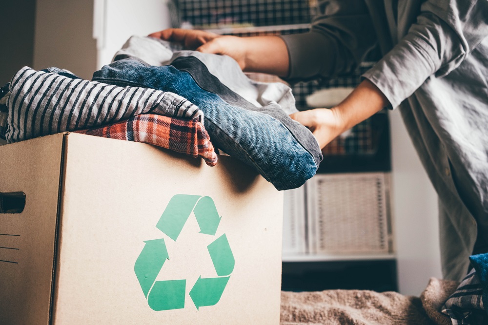 Women putting clothes in a recycling boxe.